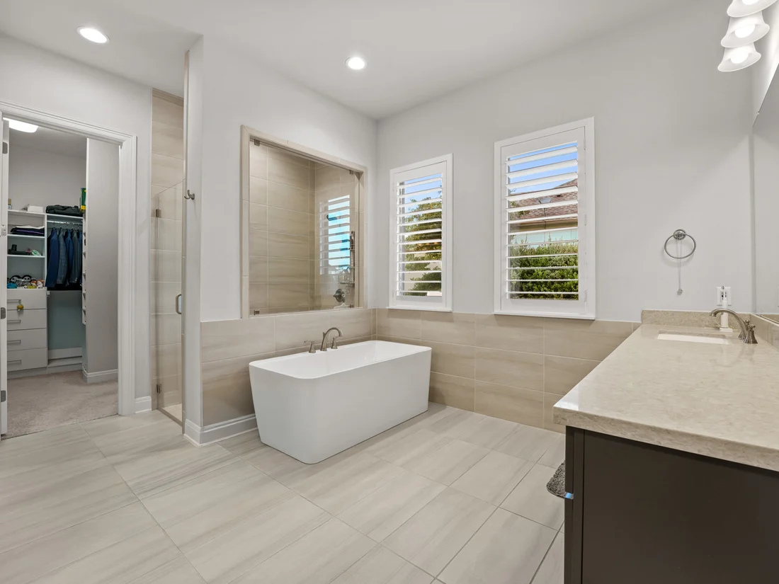 Bathroom with a freestanding soaking tub, glass shower and spacious vanity